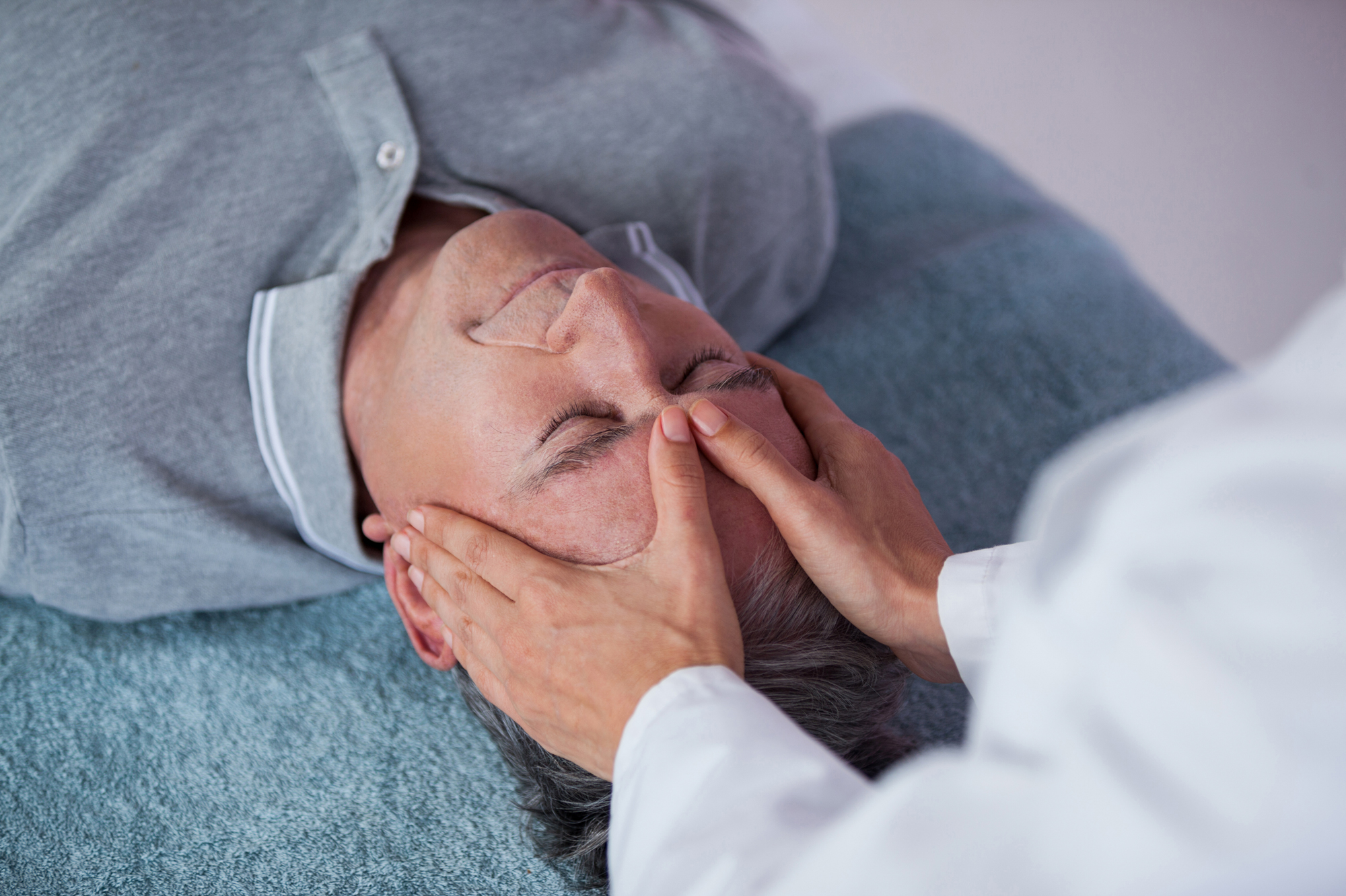 Older man receiving cranial osteopathy treatment